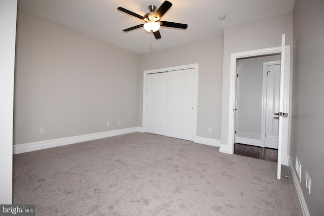 unfurnished bedroom with light colored carpet, ceiling fan, and a closet