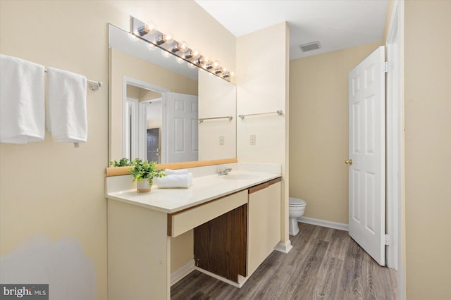 bathroom with vanity, wood-type flooring, and toilet