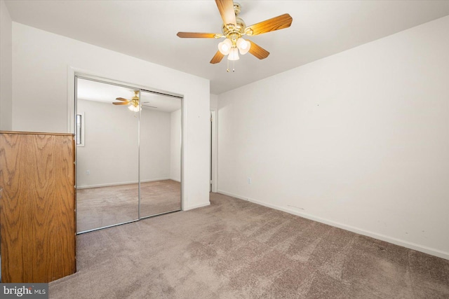 unfurnished bedroom featuring carpet, a closet, and ceiling fan