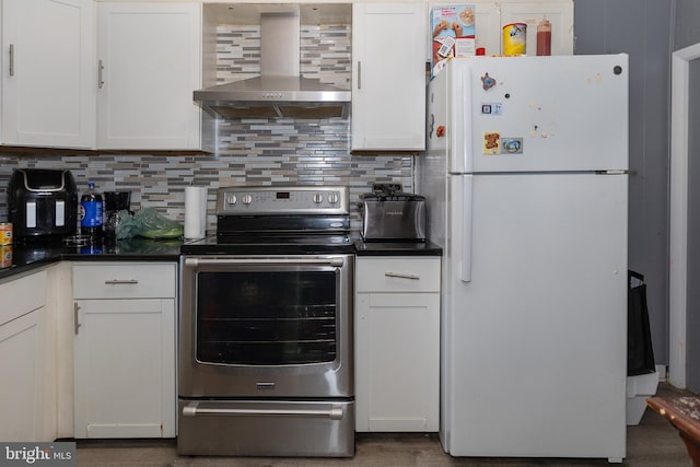 kitchen with white fridge, wall chimney range hood, electric range, and white cabinets