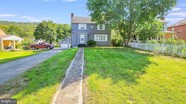 view of front of house with an outbuilding, a garage, and a front yard