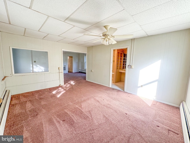 carpeted spare room with a paneled ceiling, baseboard heating, and ceiling fan