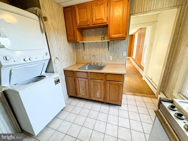 kitchen with light tile patterned flooring, sink, a baseboard heating unit, stacked washer / drying machine, and white electric range oven