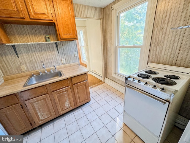 kitchen with sink, white range with electric stovetop, a baseboard radiator, and light tile patterned floors