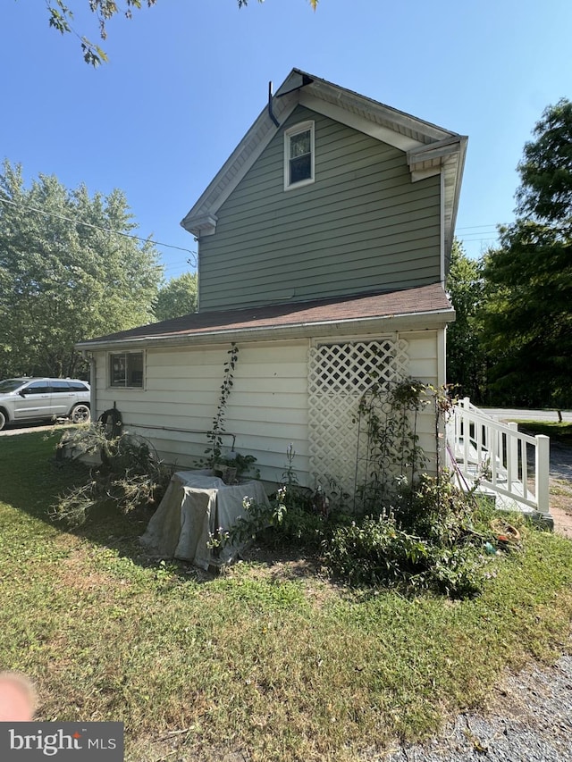 view of side of home with a yard