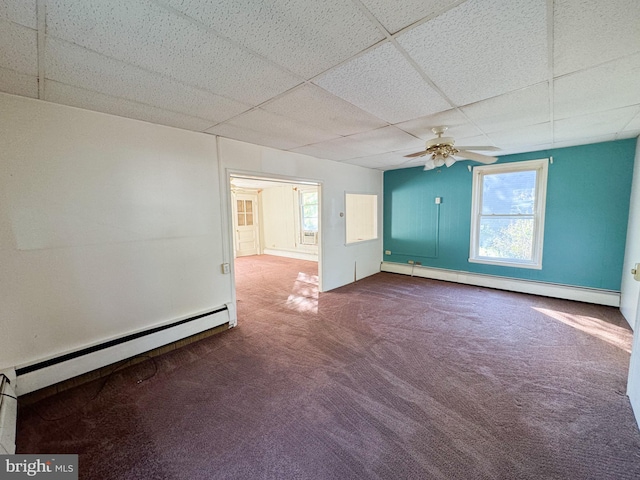 spare room with baseboard heating, a paneled ceiling, carpet floors, and ceiling fan