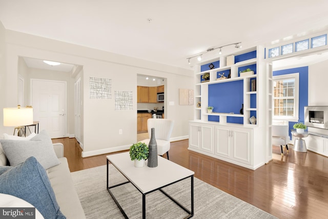 living room with wood-type flooring and track lighting