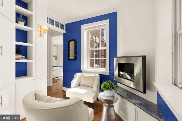 living area with built in features, dark hardwood / wood-style floors, and crown molding