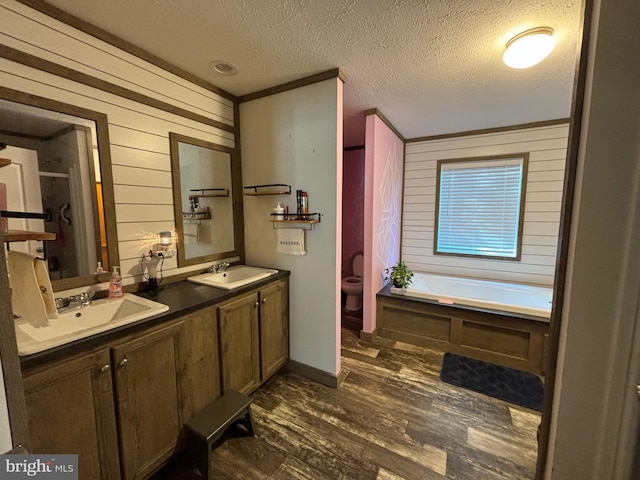 full bathroom with hardwood / wood-style floors, shower with separate bathtub, a textured ceiling, toilet, and vanity