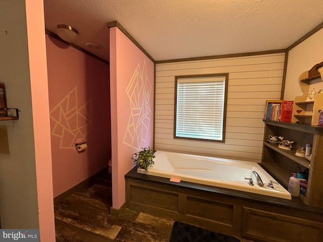 bathroom featuring toilet, a textured ceiling, a tub to relax in, and wood walls