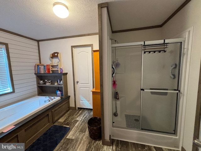 bathroom featuring crown molding, hardwood / wood-style flooring, a textured ceiling, and plus walk in shower