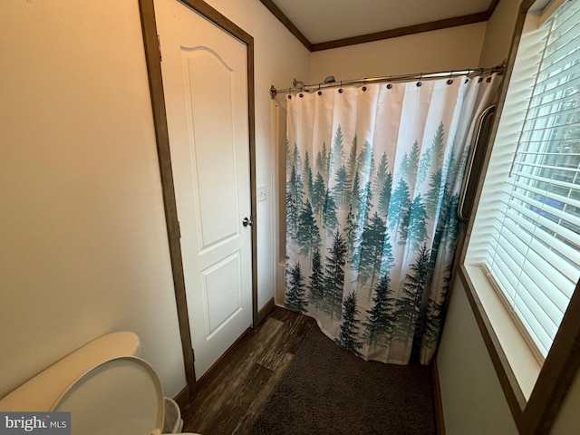 bathroom featuring toilet, ornamental molding, and hardwood / wood-style floors