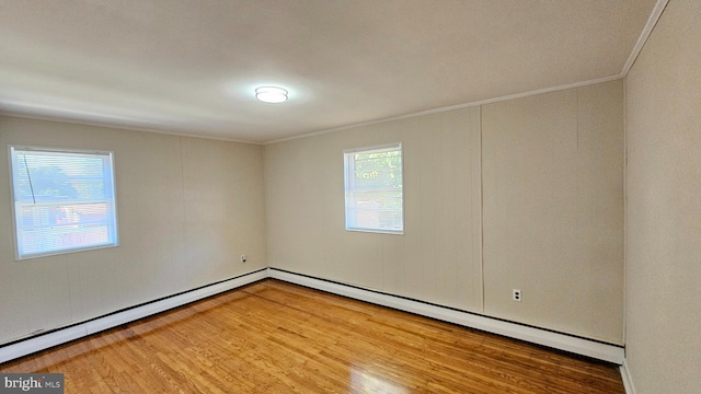 spare room featuring ornamental molding, hardwood / wood-style flooring, and a baseboard radiator