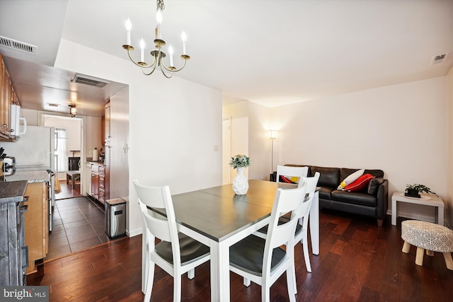 dining space with an inviting chandelier and dark hardwood / wood-style flooring