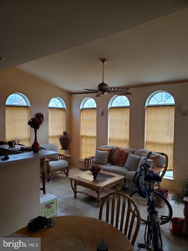 tiled living room featuring ceiling fan and a wealth of natural light