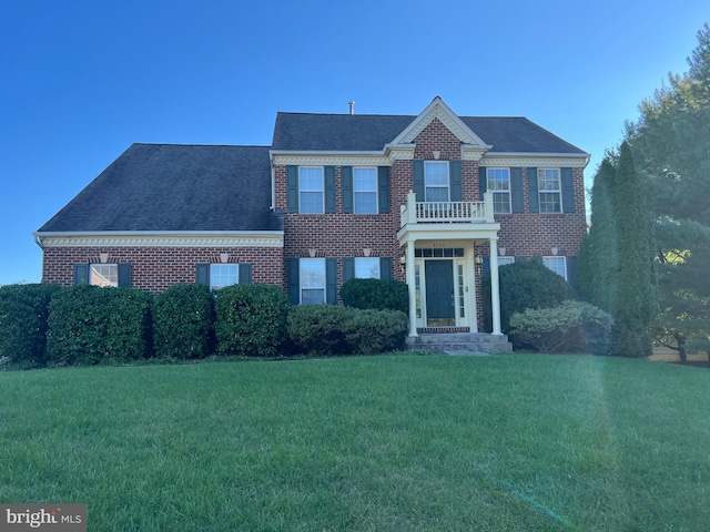 view of front of property with a balcony and a front yard