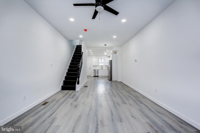 unfurnished living room featuring ceiling fan and light hardwood / wood-style floors