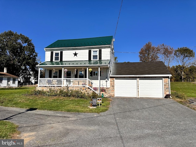 country-style home featuring a porch, a garage, and a front lawn