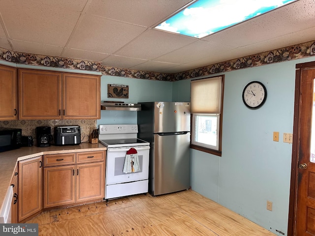 kitchen with stainless steel refrigerator, electric range, extractor fan, light hardwood / wood-style floors, and a paneled ceiling