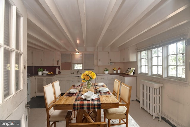 dining area with beamed ceiling, sink, and radiator heating unit