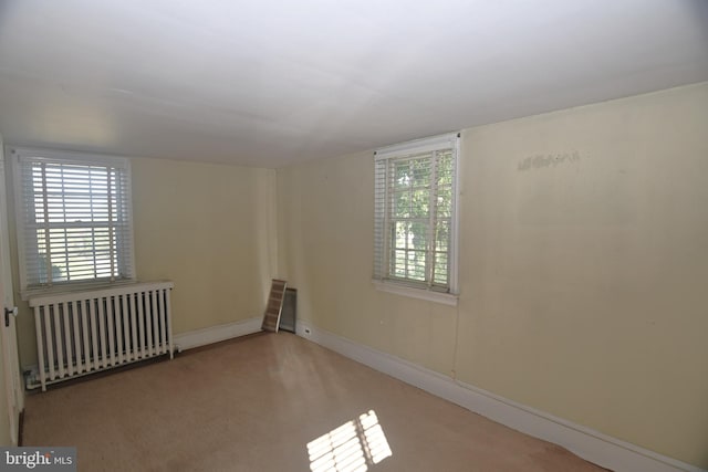 carpeted spare room featuring radiator