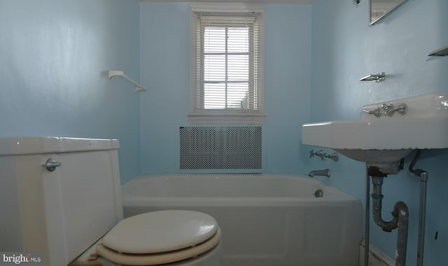 bathroom featuring toilet and a washtub