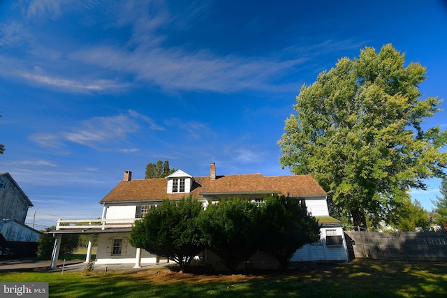 view of side of home featuring a patio area and a lawn