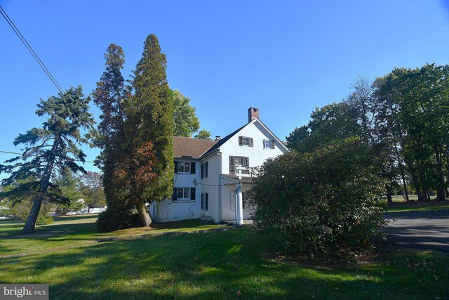 2761 York Rd, Jamison, PA 18929 - view of property exterior with a yard, stucco siding, and a chimney