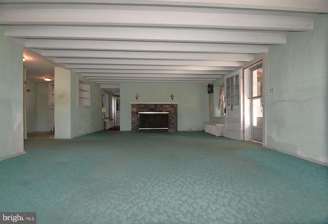 unfurnished living room featuring beamed ceiling and carpet flooring