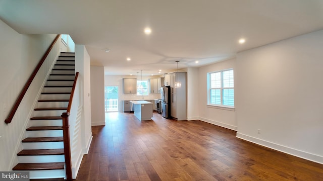 unfurnished living room with dark hardwood / wood-style floors and plenty of natural light