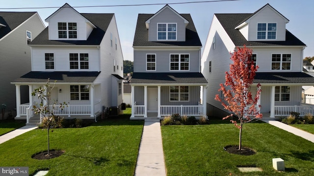 cape cod house with a front yard and covered porch