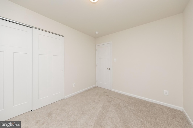 unfurnished bedroom with a closet and light carpet