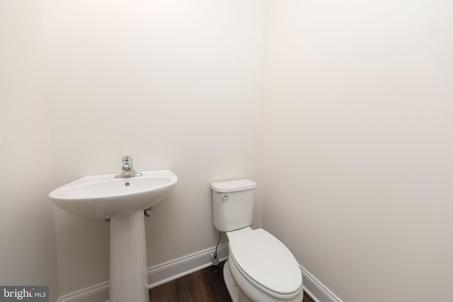 bathroom featuring wood-type flooring and toilet