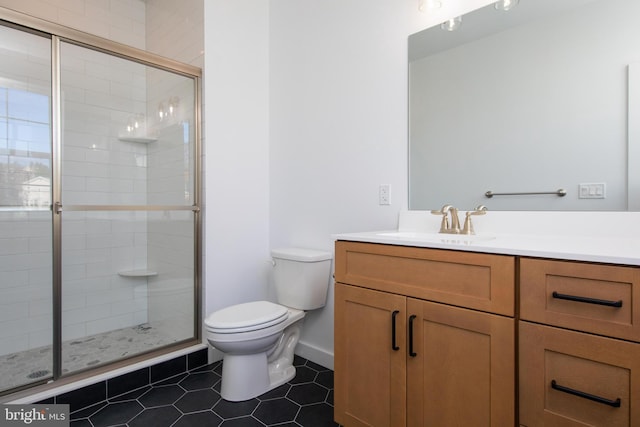 bathroom featuring toilet, vanity, tile patterned flooring, and a shower with door