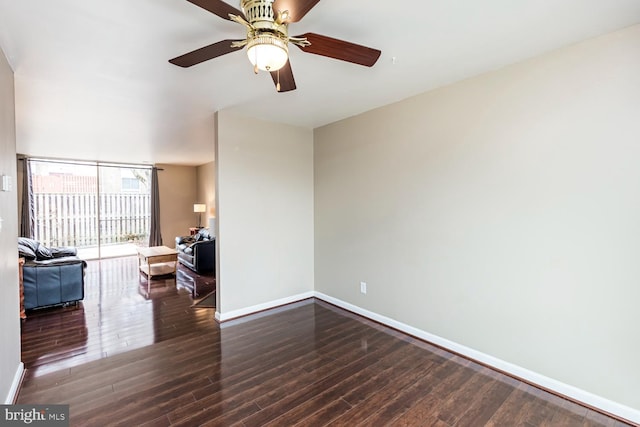 unfurnished living room with dark hardwood / wood-style flooring and ceiling fan