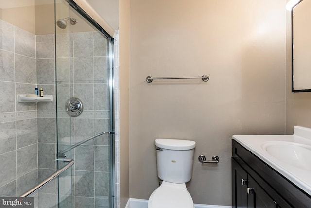 bathroom with toilet, a shower with door, and vanity