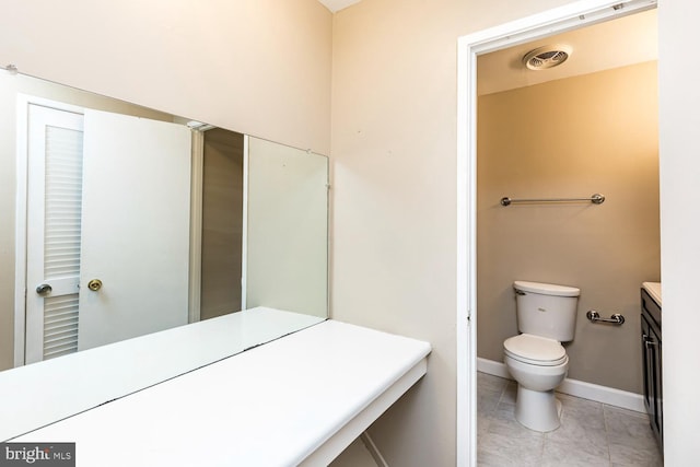 bathroom featuring vanity, tile patterned flooring, and toilet