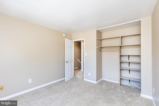 unfurnished bedroom featuring a closet and light colored carpet