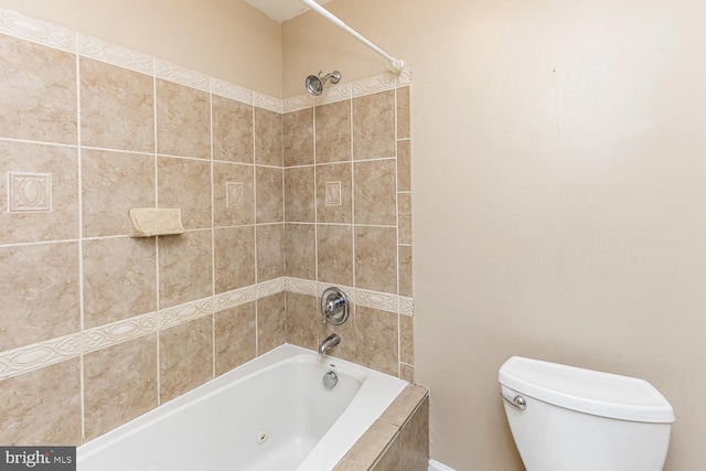 bathroom with tiled shower / bath combo and toilet