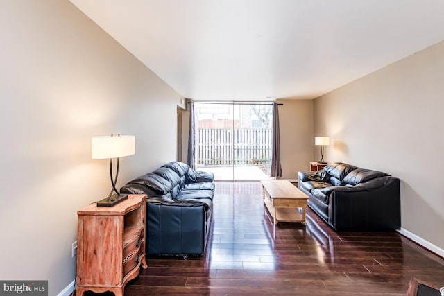 living room featuring dark wood-type flooring and floor to ceiling windows