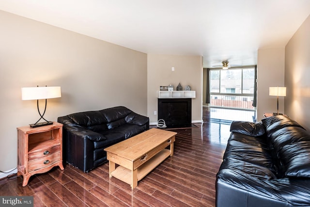 living room with ceiling fan and dark hardwood / wood-style flooring