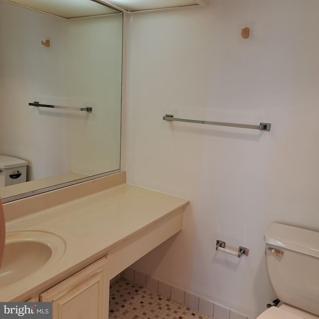 bathroom with toilet, vanity, and tile patterned floors