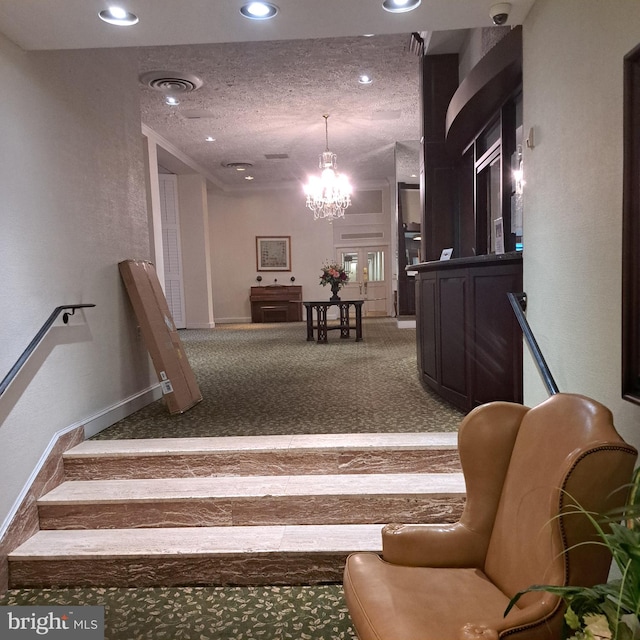 stairway with carpet, a textured ceiling, and an inviting chandelier