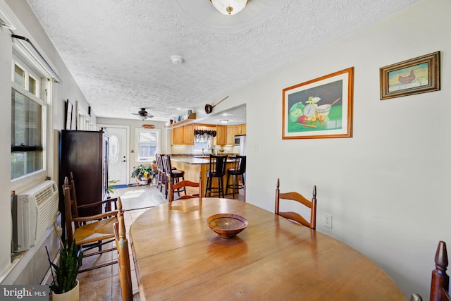 dining room with tile patterned floors, ceiling fan, and a textured ceiling