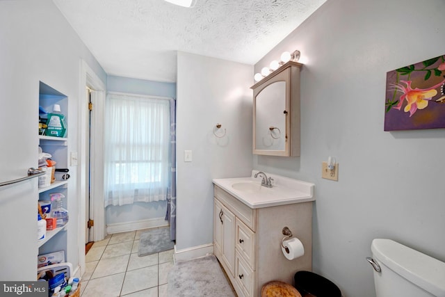 bathroom featuring tile patterned floors, vanity, toilet, and a textured ceiling