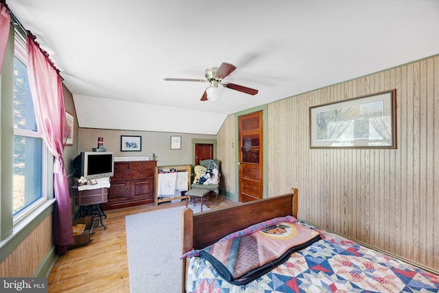 bedroom featuring multiple windows, ceiling fan, light hardwood / wood-style floors, and vaulted ceiling