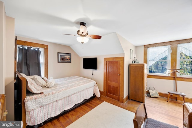 bedroom with ceiling fan, wood-type flooring, and lofted ceiling