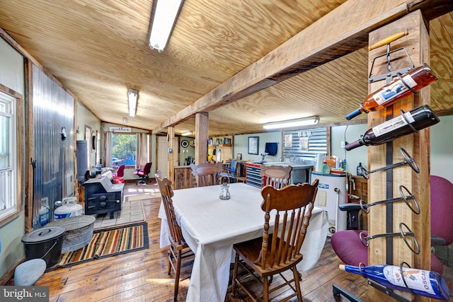 dining area featuring light hardwood / wood-style flooring, beamed ceiling, and wooden ceiling