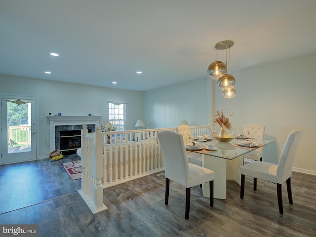 dining space featuring a premium fireplace and dark wood-type flooring