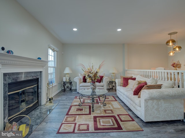 living room featuring a high end fireplace and dark wood-type flooring